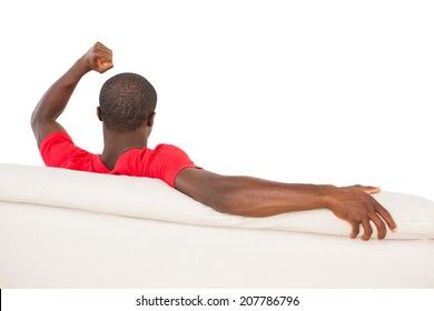 Man In Red Jersey Sitting On Couch Cheering On White Background