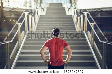 Man in red shirt preparing for stair run.