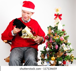 Man In Red Sweater Unwrapping A Christmas Gift