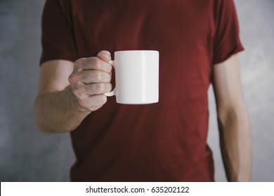 Man In Red T-shirt Holding Big White Coffee Cup.Mock Up Of Clean Coffee Cup.Horizontal Mockup.