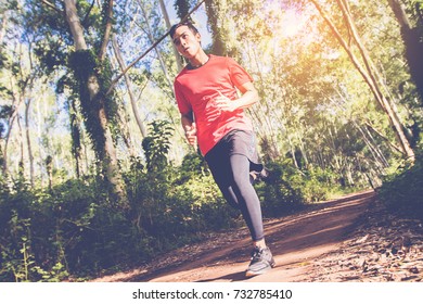man in red t-shirt runner athlete running on forest trail. motion movement