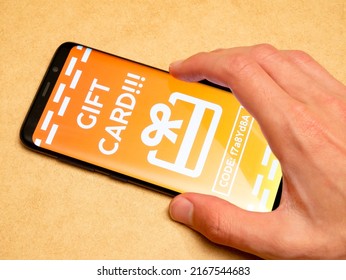 Man Redeeming A Generic Gift Card Voucher On His Smartphone, Receiving A Coupon Code In App, Mobile Phone, Hand Closeup. Online Advertising, Internet Marketing Campaign Simple Concept, One Person