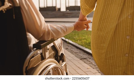 Man with reduced mobility holding wife's hand, support in relationship, love - Powered by Shutterstock