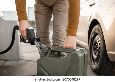Man refilling canister with fuel on the petrol station. Close up view. Gasoline, diesel is getting more expensive.