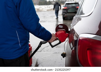 Man Refueling A Big Red Car, Quebec, Canada