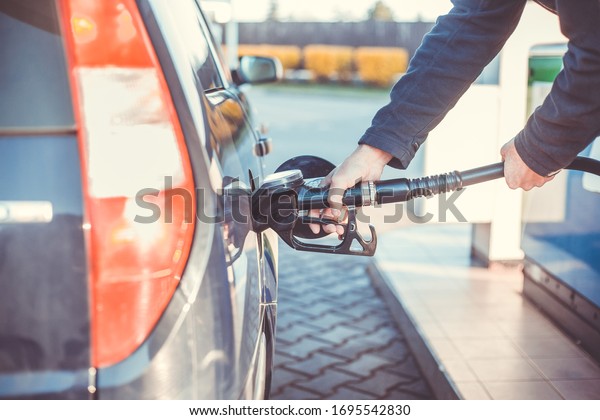 Man refueling a car during low fuel rates, fuel\
prices, transport concept