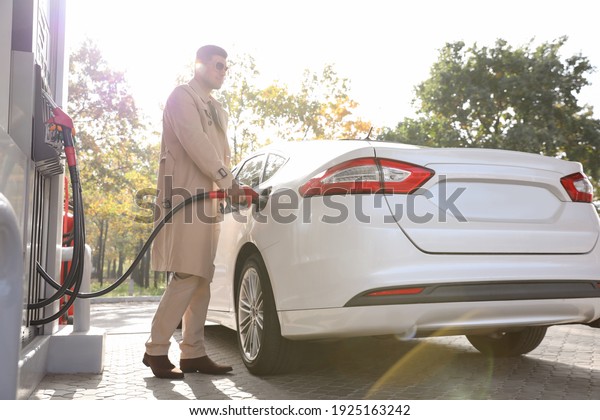 Man refueling\
car at self service gas\
station