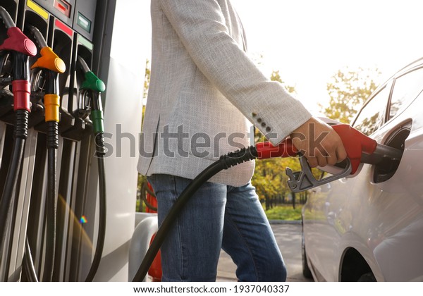 Man\
refueling car at self service gas station,\
closeup