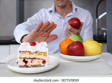 Man Refuses To Eat Unhealthy Cake And Choose Fruits For Dessert. Healthy Eating And Active Lifestyle Conceptt