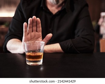 Man refuses or rejects to drink alcohol at the pub. Alcohol addiction treatment, sobriety and drinking problem. - Shutterstock ID 2142441429