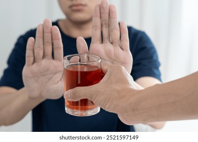 man refuses say no and avoid to drink an alcohol whiskey , stopping hand sign male, alcoholism treatment, alcohol addiction, quit booze, Stop Drinking Alcohol. Refuse Glass liquor, unhealthy, reject