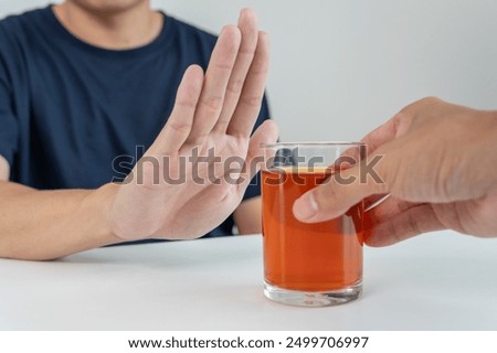 man refuses say no and avoid to drink an alcohol whiskey , stopping hand sign male, alcoholism treatment, alcohol addiction, quit booze, Stop Drinking Alcohol. Refuse Glass liquor, unhealthy, reject