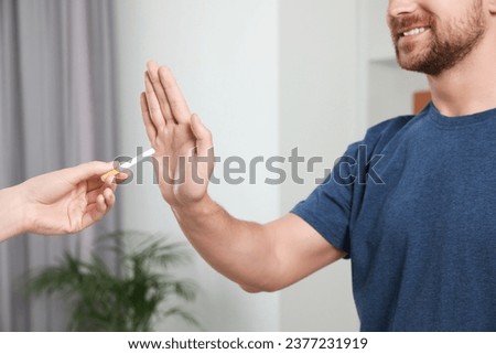 Man refusing cigarette at home, closeup. Quitting smoking concept