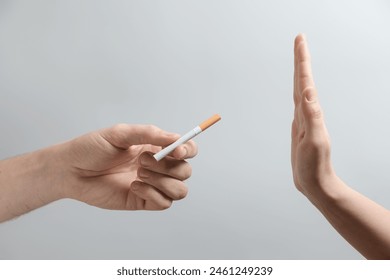 Man refusing cigarette on grey background, closeup