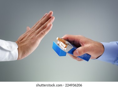 Man refusing a cigarette from a pack of smokes concept for quitting smoking and healthy lifestyle