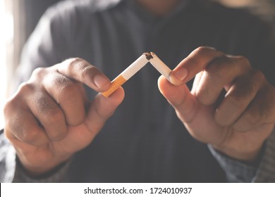 Человек отказывается от концепции сигарет для отказа от курения и здорового образа жизни на темном фоне.	