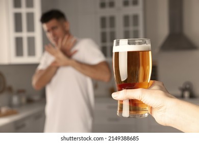 Man refusing to drink beer in kitchen, closeup. Alcohol addiction treatment