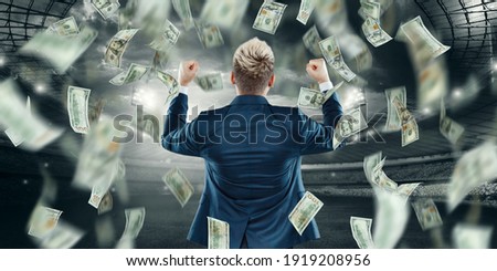 The man rejoices at the falling dollars from the sky. Concept for sports betting, gambling, bookmaker