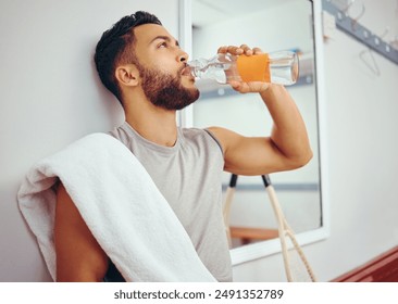 Man, relax and drinking with bottle water for hydration, natural sustainability or break at gym locker room. Young male person in recovery or thirst with mineral beverage on bench at health club - Powered by Shutterstock