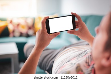 Man relaxing during using smartphone blank screen horizontal while lying on sofa - blank screen smartphone