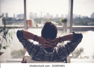 Man relaxing in his chair and enjoying the view from office window - Shutterstock ID 331893401