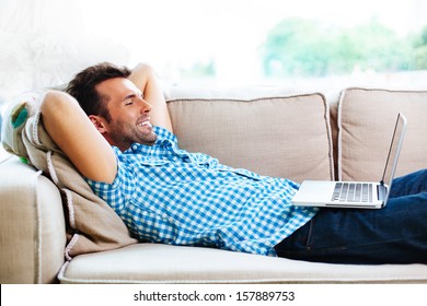 Man Relaxing With Laptop On Couch