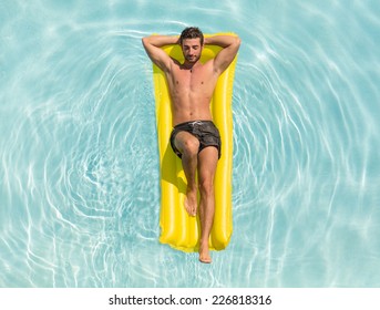 man relaxing on the air bed in the swimming pool. concept about vacation and free time