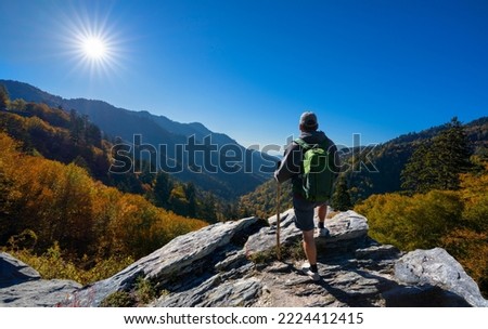 Man relaxing on autumn hiking trip. Man hiker  standing on top of the mountain enjoying beautiful fall scenery. Smoky Mountains National Park, near Gatlinburg, Tennessee, USA