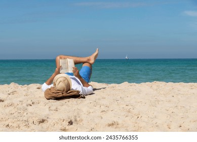 Man relaxing on the beach, reading a book.travel holidays concept - Powered by Shutterstock