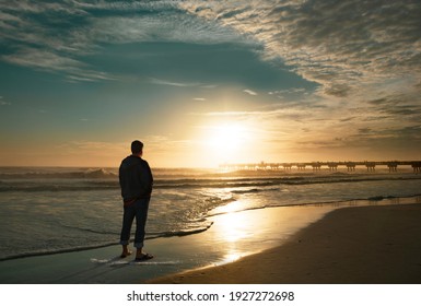 Man relaxing on the beautiful beach at sunrise. Sun  reflected on beach, Jacksonville, Florida, USA.