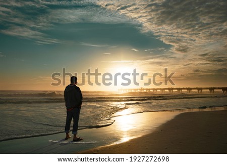 Man relaxing on the beautiful beach at sunrise. Sun  reflected on beach, Jacksonville, Florida, USA.