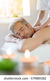 Man relaxing on massage table receiving massage 