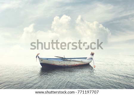 man relaxing on old boat floating in the calm water