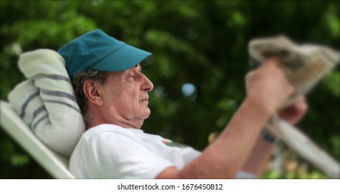 
Man Relaxing Outdoors Reading Newspaper, Turning Page