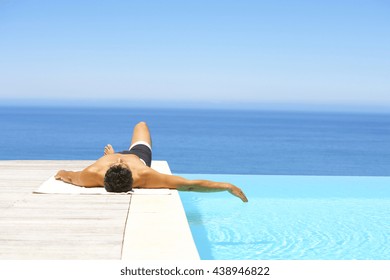 Man Relaxing At Pool Near Ocean