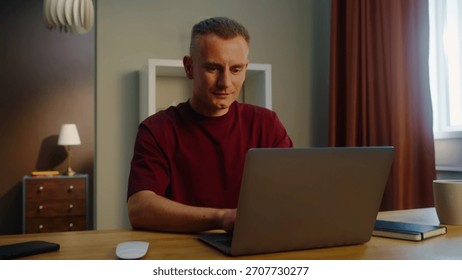 Man remote worker get ready work home. Guy come early morning sit down desk open laptop type keyboard. Male employee surfing net. Busy serious person use pc. Online computer freelancer. Distant job.