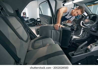 Man removes automobile seat for cleaning interior in car service - Shutterstock ID 2052028583