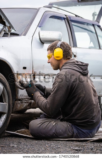 Man removes Car paint
Grinder