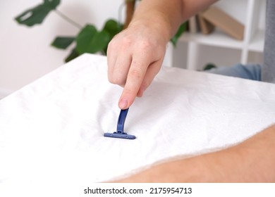 A man removes fabric pills using a disposable shaving machine. A razor for removing pellets.