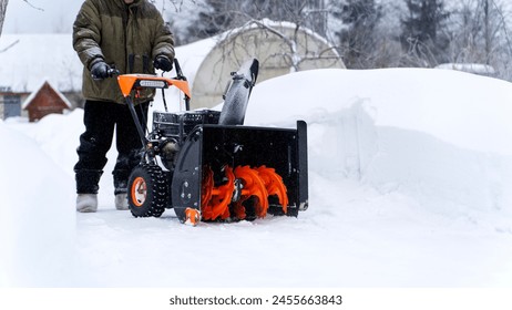 A man removes snow with a snow blower - Powered by Shutterstock