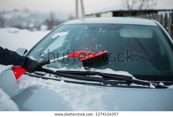 man removes
snow from the car. the guy is
snowing