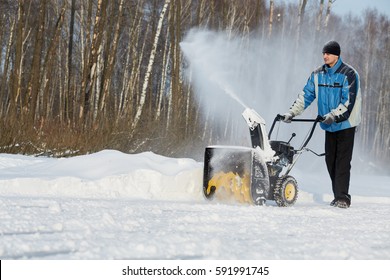 Man Removes Snow With Gas Snow Thrower At Winter Day.