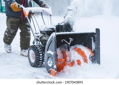 a man removes snow with a snow plow after a heavy snowfall near his house, close-up, blizzard, snow in the lens, selective focus, snow