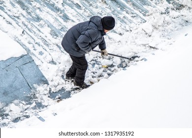 A Man Removes Snow Shovel Top View, Metal Roof.