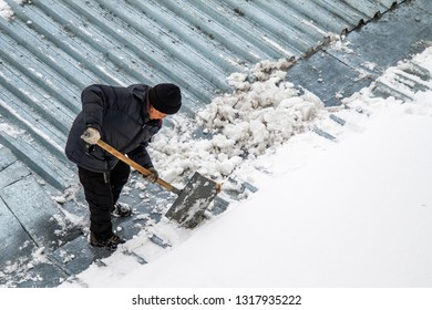 A Man Removes Snow Shovel Top View, Metal Roof.