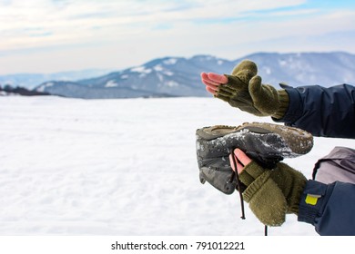 Man Removing Snow From His Shoe On A Winter Hiking Trip