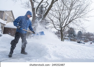 Man Removing Snow With A Shovel 