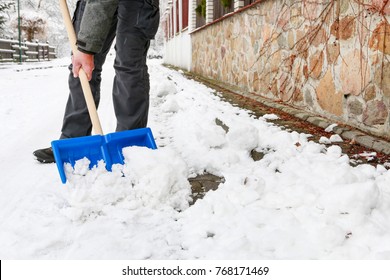 Man Removing Snow From The Sidewalk After Snowstorm.