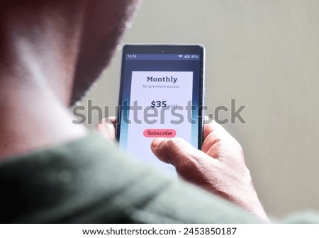 Man renewing monthly subscription plan for streaming service or educational program or delivery benefits on his smartphone. selective focus.