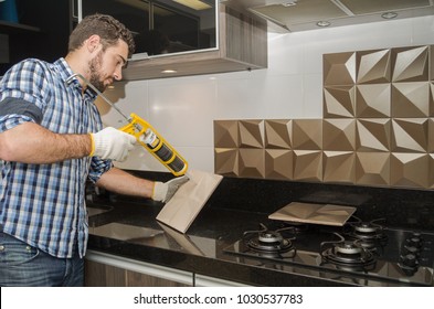 Man Renovating, Renovating The Kitchen, Installing Tile On The Wall.